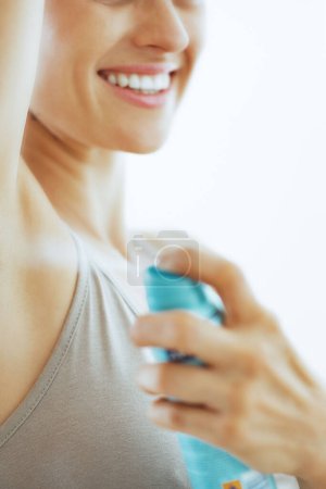 Téléchargez les photos : Gros plan sur la jeune femme appliquant déodorant sur les aisselles - en image libre de droit