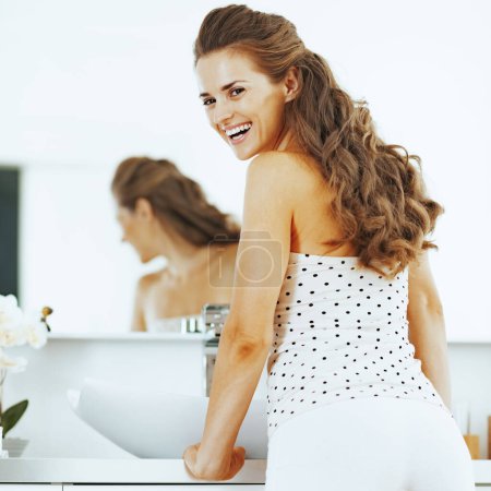 Téléchargez les photos : Souriant jeune femme dans la salle de bain - en image libre de droit