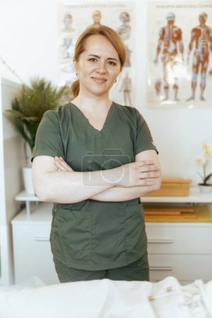 Photo for Healthcare time. Portrait of happy female massage therapist in massage cabinet. - Royalty Free Image