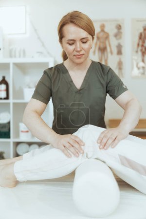 Photo for Healthcare time. pensive female medical massage therapist in massage cabinet with client conducting examination. - Royalty Free Image