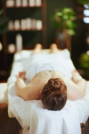 Foto de Tiempo de atención médica. mujer moderna relajada en gabinete de masaje que pone en la mesa de masaje. - Imagen libre de derechos