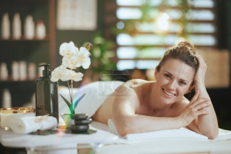 Téléchargez les photos : Temps de santé. femme moderne heureuse dans l'armoire de massage pose sur la table de massage. - en image libre de droit