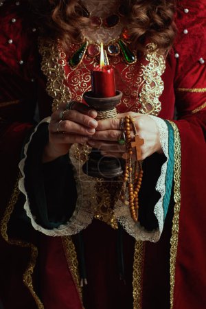 Photo for Closeup on medieval queen in red dress with candle. - Royalty Free Image
