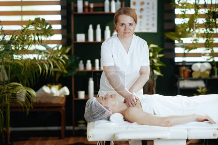 Foto de Tiempo de atención médica. terapeuta de masaje médico en el gabinete de masaje de los clientes pecho en la mesa de masaje. - Imagen libre de derechos