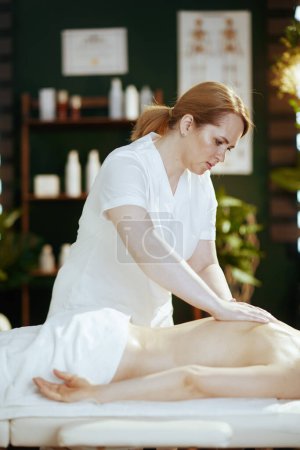 Foto de Tiempo de atención médica. masajista en gabinete de masaje masajeando a los clientes de nuevo en la mesa de masaje. - Imagen libre de derechos