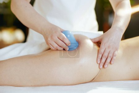 Tiempo de atención médica. Primer plano del terapeuta de masaje médico en el gabinete de masaje con silicona masaje taza clientes de masaje nalgas.