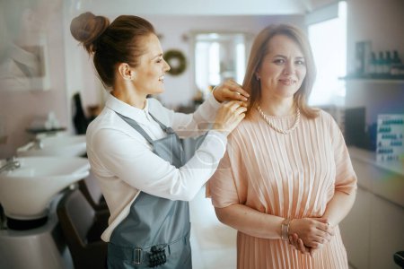 Téléchargez les photos : Femme salon de coiffure travailleur dans le studio de beauté moderne avec le client. - en image libre de droit
