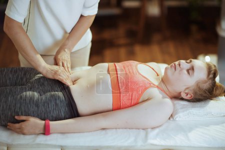 Temps de santé. massothérapeute médicale féminine dans une armoire de massage avec un client adolescent faisant un check-up sur une table de massage.
