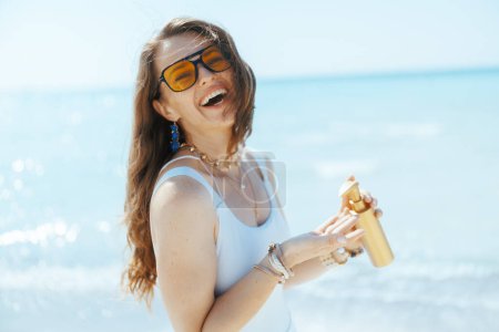 Photo for Happy modern female on the ocean shore with spf. - Royalty Free Image