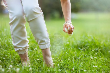 Photo for Summer time. Closeup on woman with repellent spray in the meadow outside in nature. - Royalty Free Image