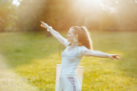 Foto de Hora de verano. sonriente mujer elegante en camisa blanca en el prado al aire libre. - Imagen libre de derechos