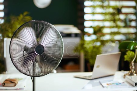 L'heure d'été. ventilateur électrique dans le bureau vert moderne.