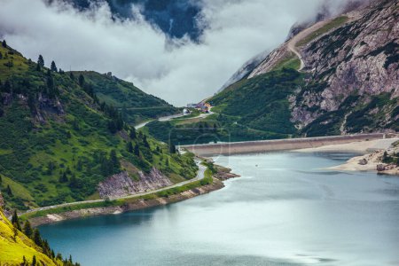 Téléchargez les photos : Heure d'été dans les Dolomites. paysage avec montagnes, collines, lac Fedaia, arbres et brouillard. - en image libre de droit