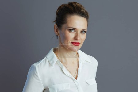 modern 40 years old small business owner woman in white blouse isolated on gray.