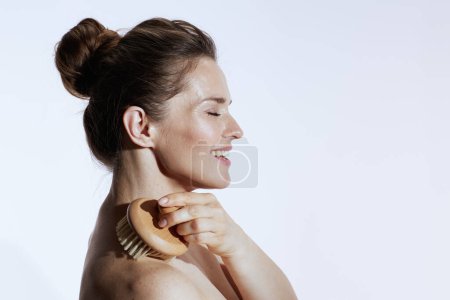 Foto de Sonriente mujer de mediana edad con masajeador aislado sobre fondo blanco. - Imagen libre de derechos