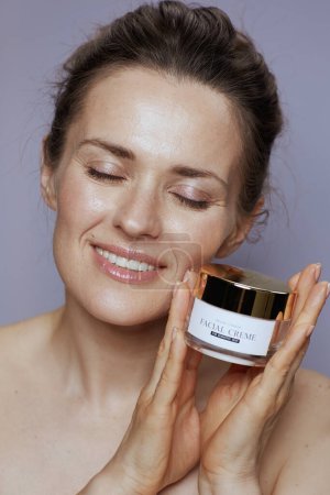 Photo for Relaxed modern female with cosmetic cream jar. - Royalty Free Image