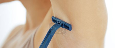 Photo for Closeup on young woman shaving armpit - Royalty Free Image