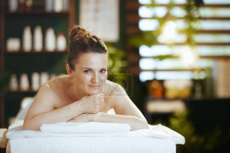 Téléchargez les photos : Temps de santé. moderne détendue 40 ans femme dans le salon de spa pose sur la table de massage. - en image libre de droit