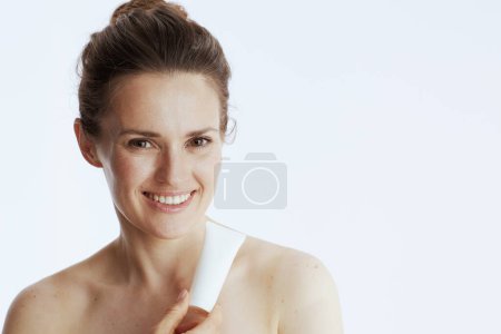 Foto de Sonriente joven con tarro de crema cosmética aislado en blanco. - Imagen libre de derechos