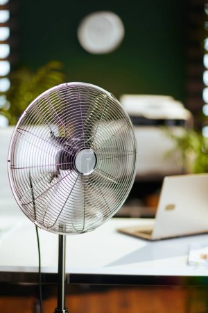Foto de Hora de verano. ventilador eléctrico en moderna oficina verde. - Imagen libre de derechos