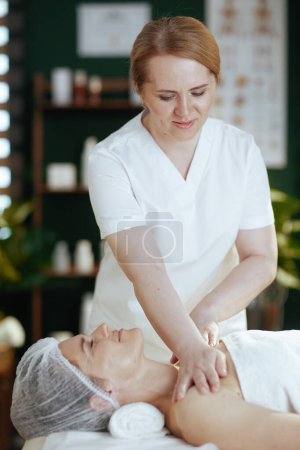Foto de Tiempo de atención médica. masajista en gabinete de masaje masajeando clientes hombro sobre mesa de masaje. - Imagen libre de derechos