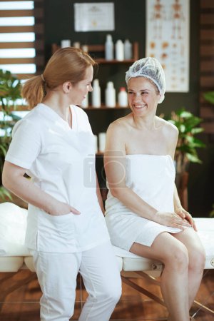 Téléchargez les photos : Temps de santé. massothérapeute médical dans le salon de spa avec client heureux sur table de massage. - en image libre de droit