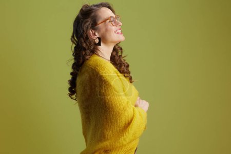 Téléchargez les photos : Heureuse femme en forme sur fond vert en pull jaune et lunettes. - en image libre de droit