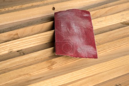 Photo for Piece of sandpaper on stacked pile of wooden slats closeup - Royalty Free Image