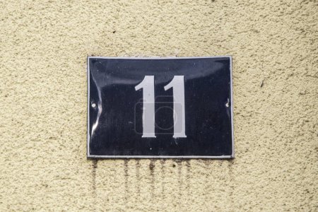 Placa esmaltada de metal cuadrado de grunge envejecido del número de dirección de la calle con el número 11