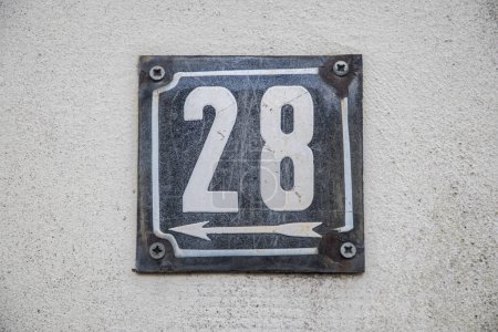 Placa esmaltada de metal cuadrado de grunge envejecido del número de dirección de la calle con el número 28 aislado en fondo blanco