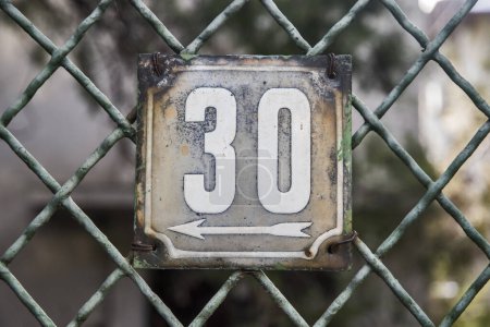 Placa esmaltada de metal cuadrado de grunge envejecido del número de dirección de la calle con el número 30 aislado en fondo blanco