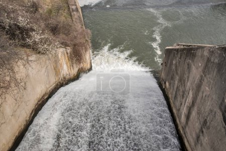 Rejet d'eau d'une écluse sur un closeup de mur de barrage