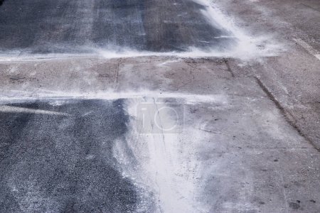 Foto de Nuevo parche de asfalto colocado en el primer plano de la carretera reparada - Imagen libre de derechos