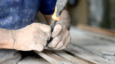 professioneller Tischler bei der Arbeit, er schnitzt Holz mit einem Holzbearbeitungswerkzeug, Tischlerei und Handwerkskunst-Konzept