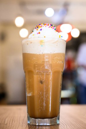 Photo for Close-up of a delicious frappuccino topped with whipped cream and vibrant sprinkles - Royalty Free Image