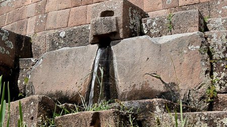 Water fountain emanating between the stones of the Sacred Valley of the Incas in Pisaq - Cusco