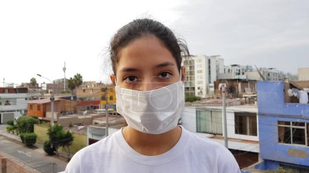 Mädchen, junge Frau mit steriler medizinischer Schutzmaske auf dem Gesicht, die in die Kamera im Freien blickt. Luftverschmutzung, Virus, chinesisches Coronavirus-Pandemiekonzept