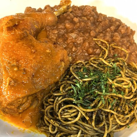 Gros plan sur un plat mexicain classique composé de mole poblano, de haricots frits salés et de spaghettis verts infusés d'herbes