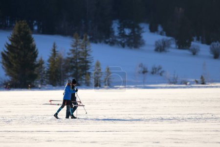 Téléchargez les photos : Weissensee, Autriche - 8 février 2022 : Lac Weissensee (Autriche) par une journée froide et ensoleillée en hiver, les gens marchent - en image libre de droit