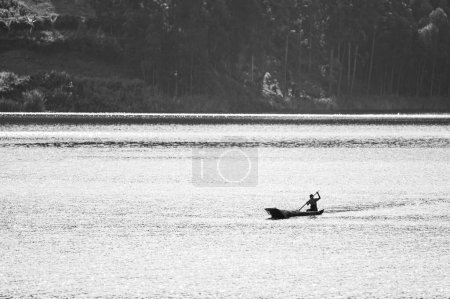 Photo for Kabale, Uganda - June 12, 2022: Man in a dugout canoe on Lake Bunyonyi (Uganda), sunny day in summer - Royalty Free Image
