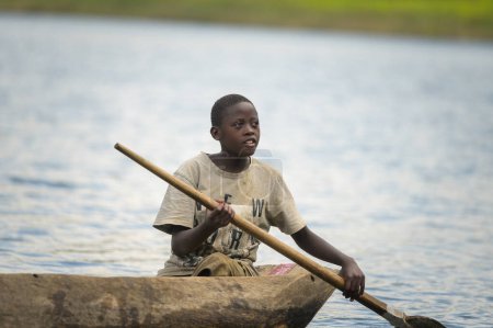 Photo for Kabale, Uganda - June 12, 2022: Children in a dugout canoe on Lake Bunyonyi (Uganda), sunny day in summer - Royalty Free Image