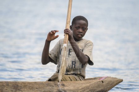 Photo for Kabale, Uganda - June 12, 2022: Children in a dugout canoe on Lake Bunyonyi (Uganda), sunny day in summer - Royalty Free Image