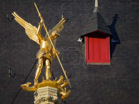Foto de A golden angel statue killing the evil dragon with a spear, daylight, building, Bruges (Belgium) - Imagen libre de derechos