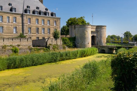 Foto de Bergues, France - July 5. 2022: An old city wall with surveillance towers, city gate and bridge, clear day, blue sky - Imagen libre de derechos