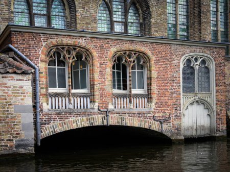 Foto de Bruges, Belgium-July 4, 2022: An old house with a small bridge, daylight, summer - Imagen libre de derechos