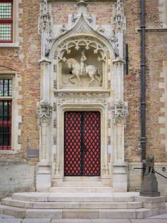 Foto de Bruges, Belgium-July 4, 2022: An old house with a red door, antique, daylight - Imagen libre de derechos