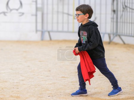 Téléchargez les photos : Arles, France - 11 mars 2023 : Garçon jouant au Capea du Forum, un événement traditionnel gratuit organisé par l'école Taurine d'Arles - en image libre de droit