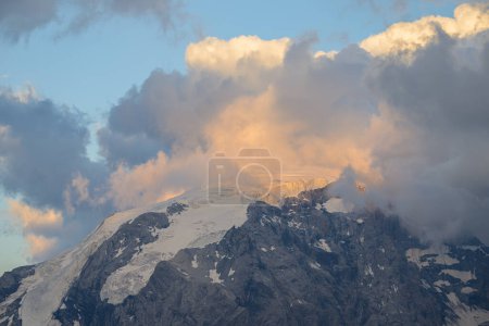 The Ortler Alps near Stelvo Pass at sunset in summer, clouds around the peak