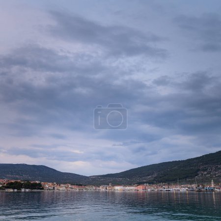 Calm sea near Cres after sunset in springtime, cloudy sky