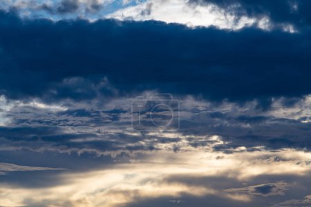 Una fotografía con nubes grises oscuras contrastantes que llenan casi todo el cielo azul de la fotografía